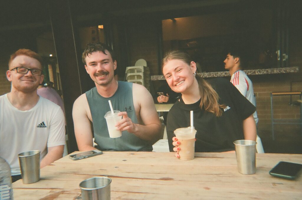 Three runners laughing over coffee after a run