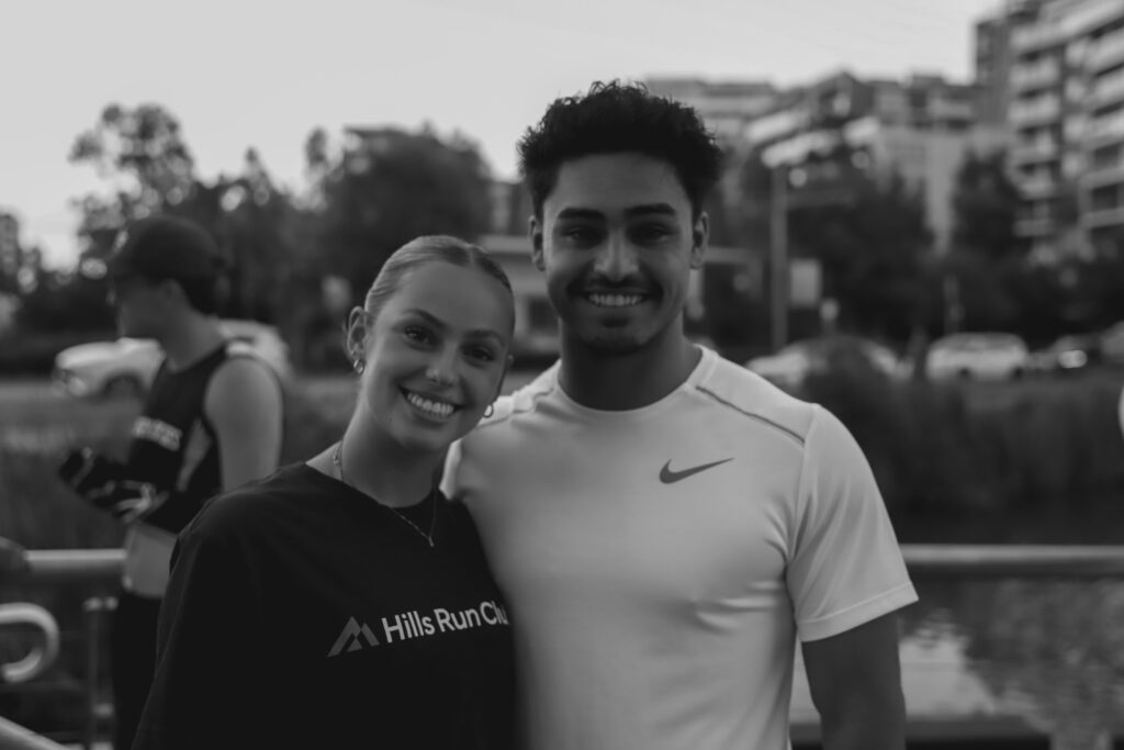Two runners smiling together at a Hills Run Club run