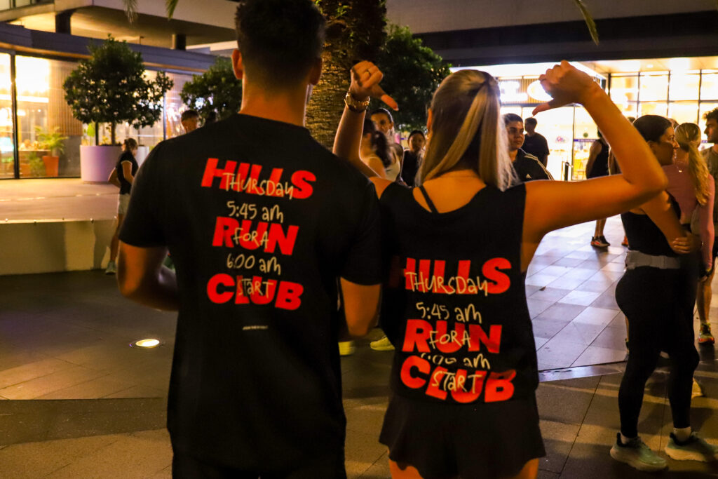 Hills Run Club runners in club tops at a night run