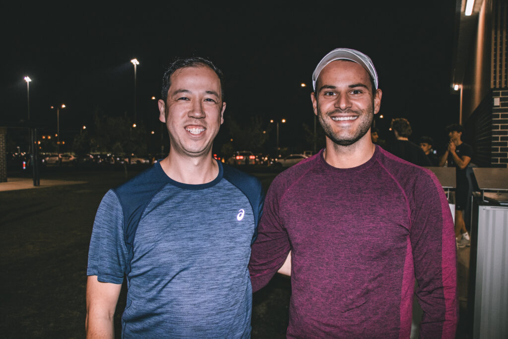 Three smiling Hills Run Club members standing together outdoors at a night run