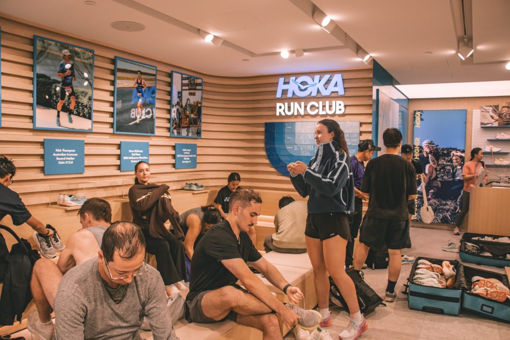 HRC+ members trying on new HOKA running shoes before the run